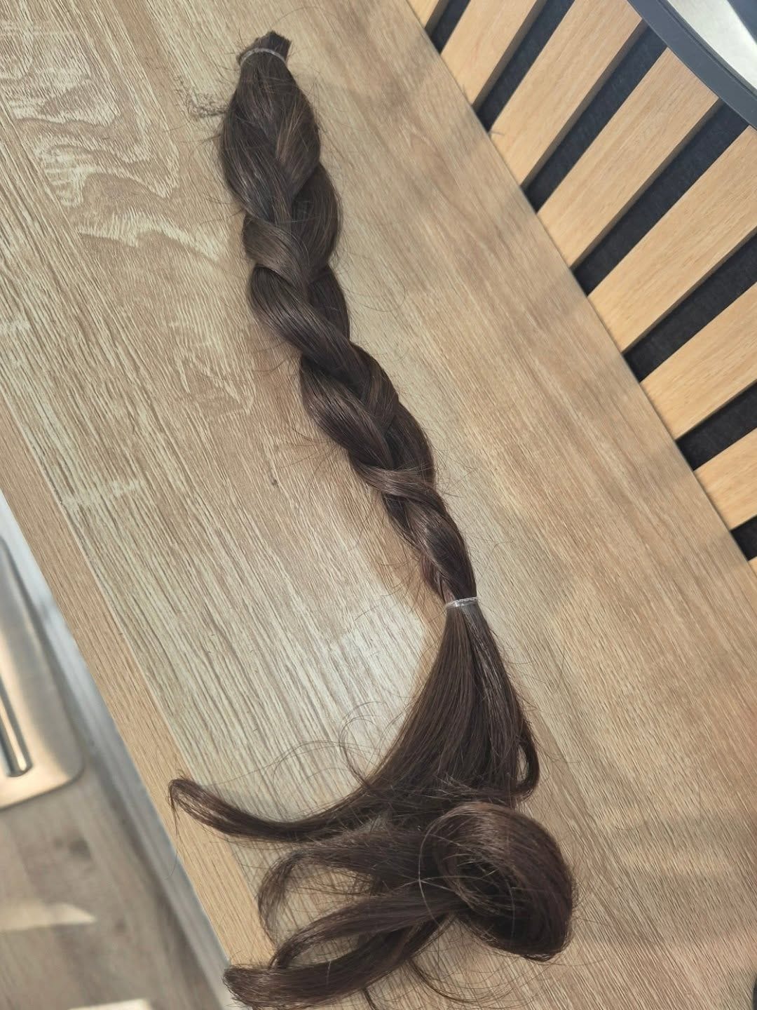 Ein abgeschnittener, geflochtener Zopf für eine Haarspende